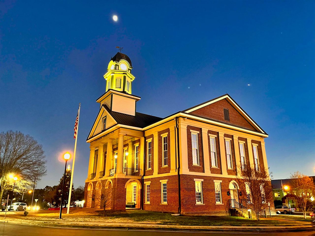Historic American county courthouse with flag at dusk